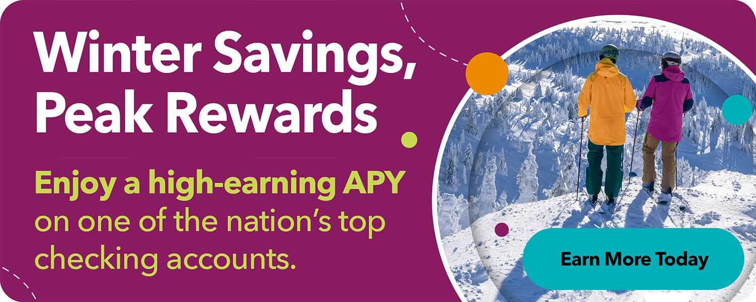 Two people standing on a snowy mountain overlook, representing Kitsap Credit Union’s Winter Savings Peak Rewards promotion.