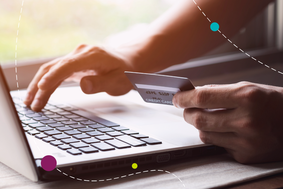 Person on laptop holding card