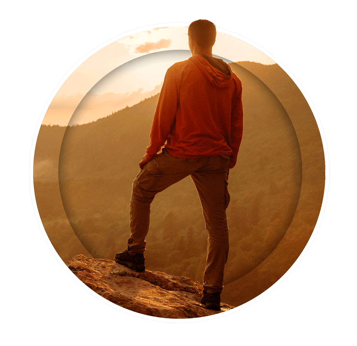 Man standing at sunrise on a mountain peak.
